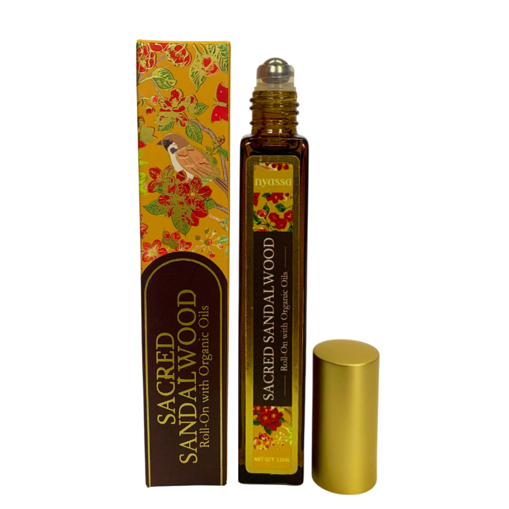 Sacred Sandalwood roll-on bottle with decorative packaging on a white background