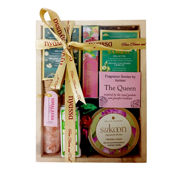 Gift set with products including a bottle, a box, and a container, all tied together with a ribbon.